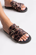 Leopard print sandals with gold buckles on a light gray background